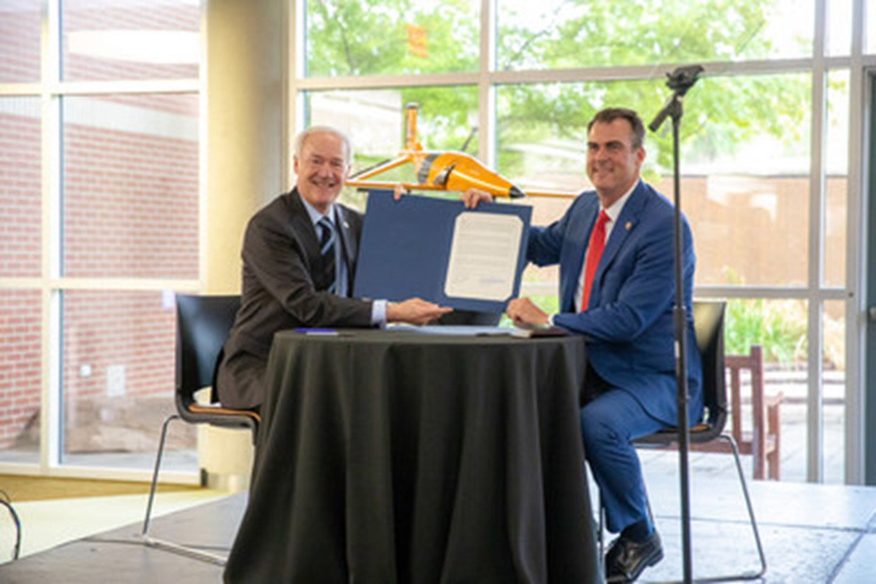 Arkansas Gov. Asa Hutchinson, left, and his Oklahoma counterpart, Gov. Kevin Stitt, show off their agreement to create an R&D and Innovation hub for advanced mobility technologies.